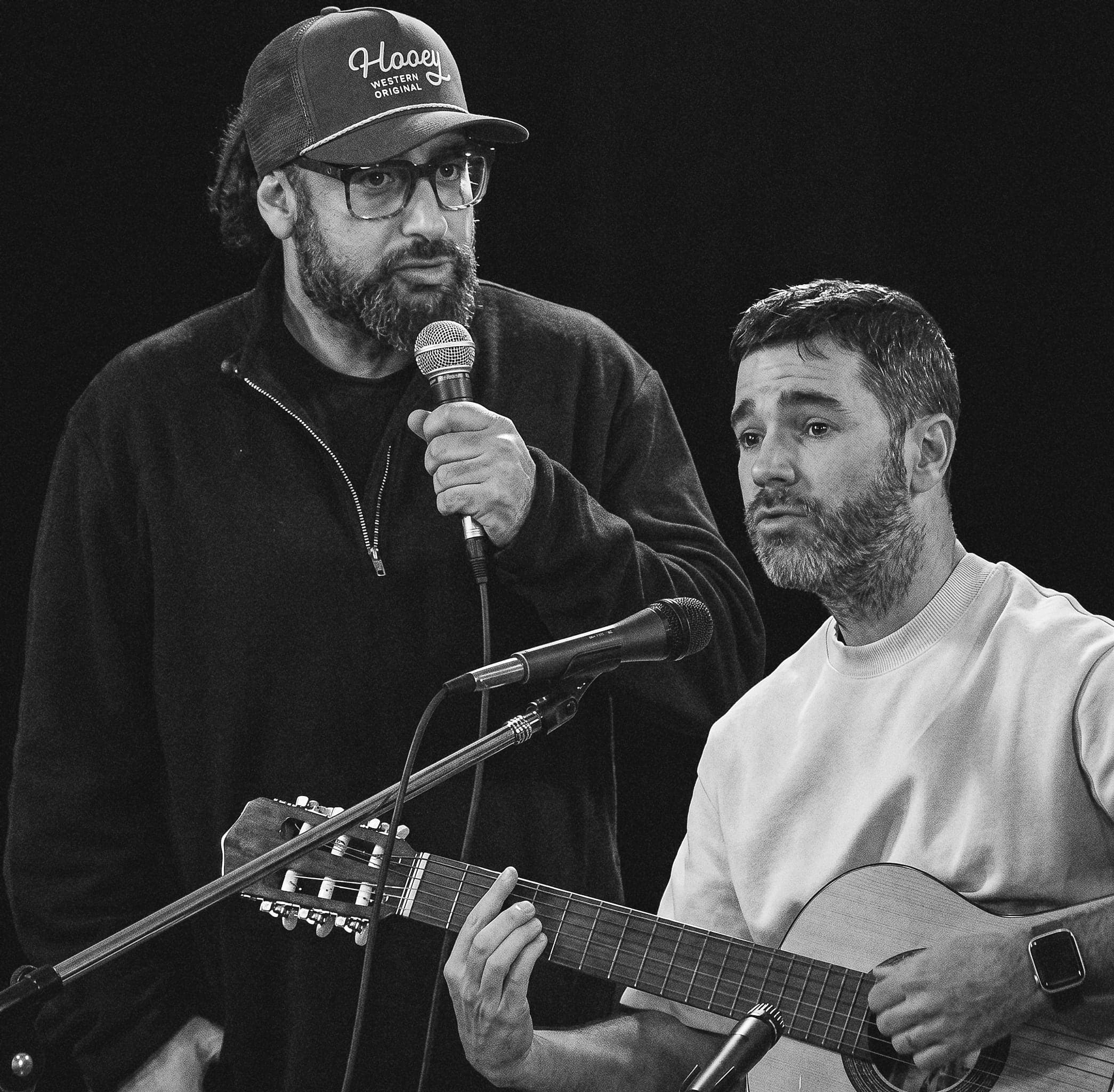 En vivo: uno canta con micrófono en mano y el otro toca la guitarra criolla